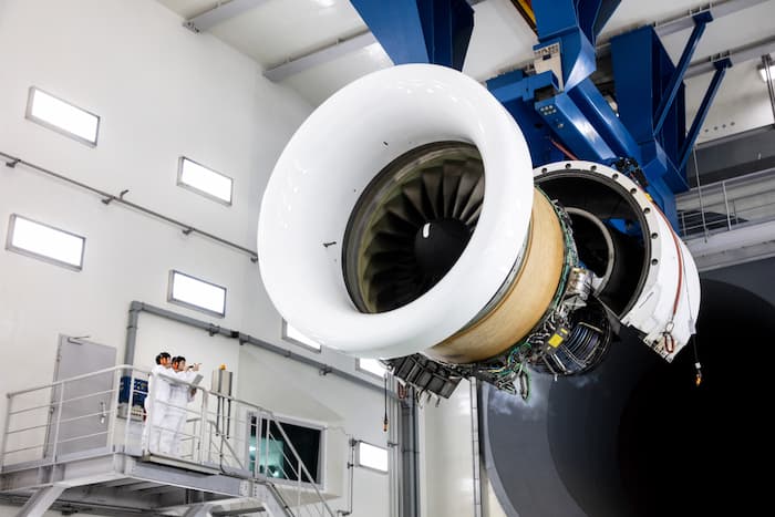 Large aircraft engine mounted inside Korean Air’s engine test cell facility with engineers observing from a platform
