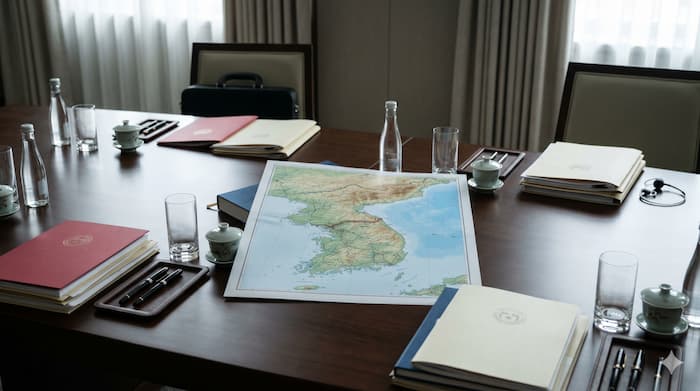 남북 경계 관리 합의를 상징하는 회담 테이블과 한반도 지도 이미지