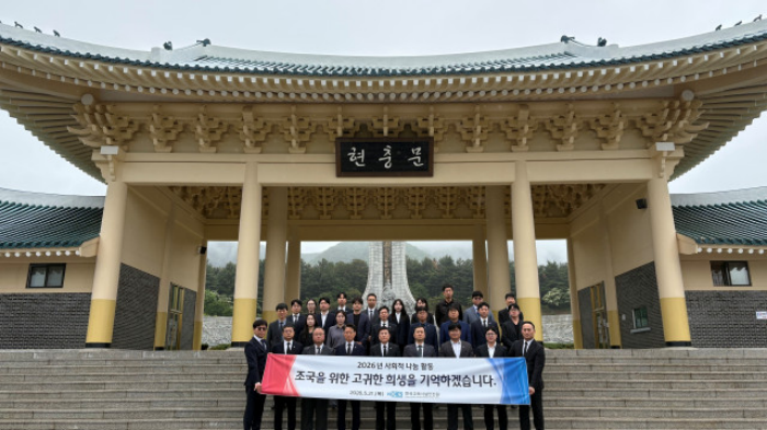 한국교육시설안전원 임직원들이 국립대전현충원에서 태극기 꽂기 봉사활동 후 기념촬영을 하고 있다