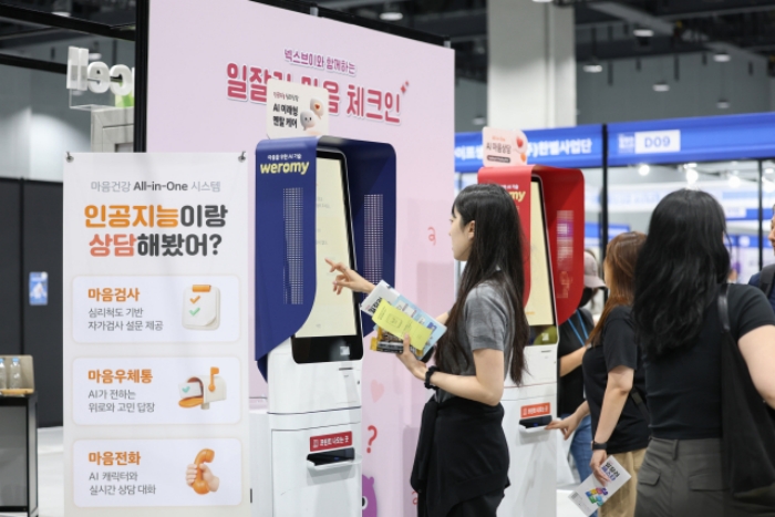2026 일잘러 페스타 특별관에서 참관객이 AI 상담 체험형 기기를 살펴보는 장면