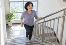 “걷기만 해선 부족하다?”…하루 20분 계단 오르기, 혈압 낮추는 현실 운동법 중년 여성이 안전바를 잡고 계단 오르기 운동을 하는 모습