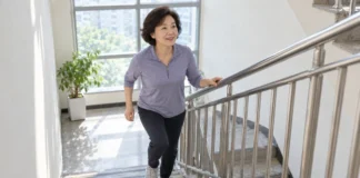 “걷기만 해선 부족하다?”…하루 20분 계단 오르기, 혈압 낮추는 현실 운동법 중년 여성이 안전바를 잡고 계단 오르기 운동을 하는 모습