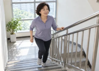“걷기만 해선 부족하다?”…하루 20분 계단 오르기, 혈압 낮추는 현실 운동법 중년 여성이 안전바를 잡고 계단 오르기 운동을 하는 모습