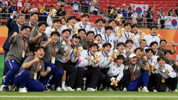 아시안게임 남자축구 우승 뒤 금메달과 마스코트를 들고 환호하는 한국 대표팀 선수와 코칭스태프