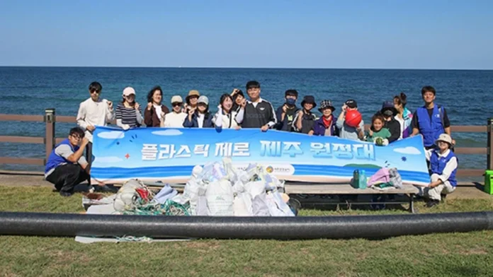 jeju-plastic-zero-expedition-2026-group 제주 해안에서 수거한 쓰레기 앞에 모여 기념촬영하는 플라스틱 제로 제주 원정대 참가자들