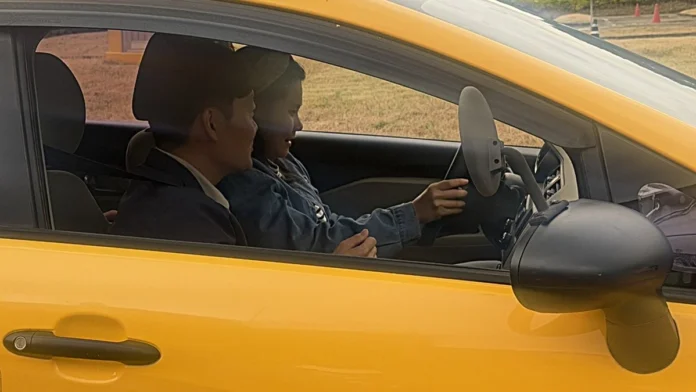 시각장애인 참가자가 시험관 동승 아래 시험용 차량을 운전하는 모습