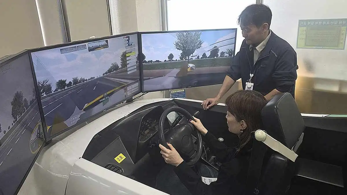 실제 차량 체험에 앞서 운전 시뮬레이터로 조작법을 배우는 참가자